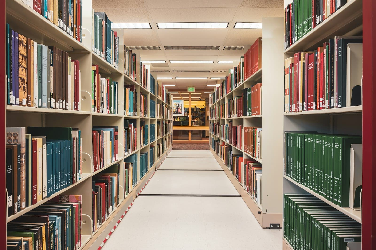 Long, bright library aisle lined with bookshelves